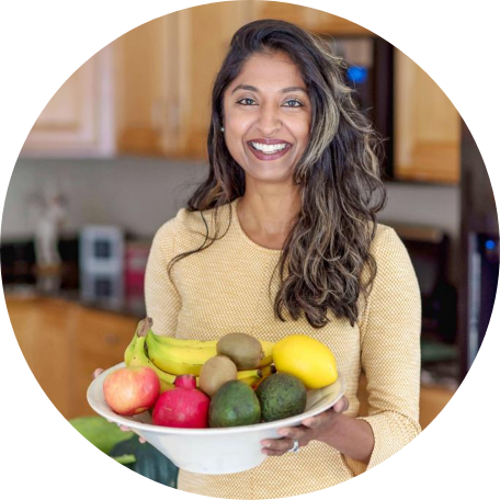 Raman Magay holding a bowl of fruit in a kitchen setting